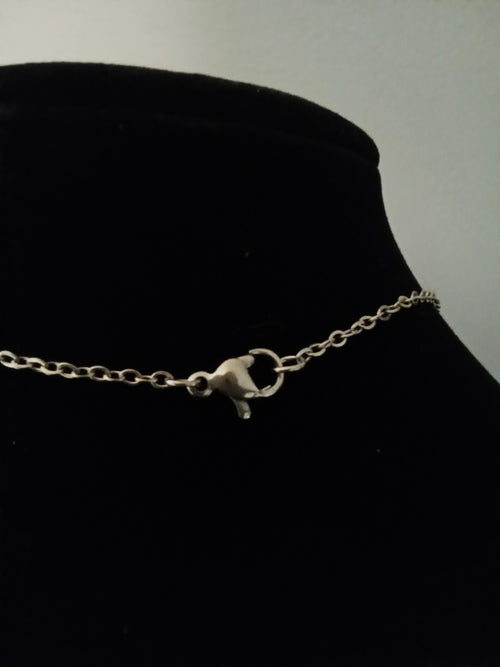 A gold chain necklace with a lobster clasp, displayed on a black velvet jewelry bust.